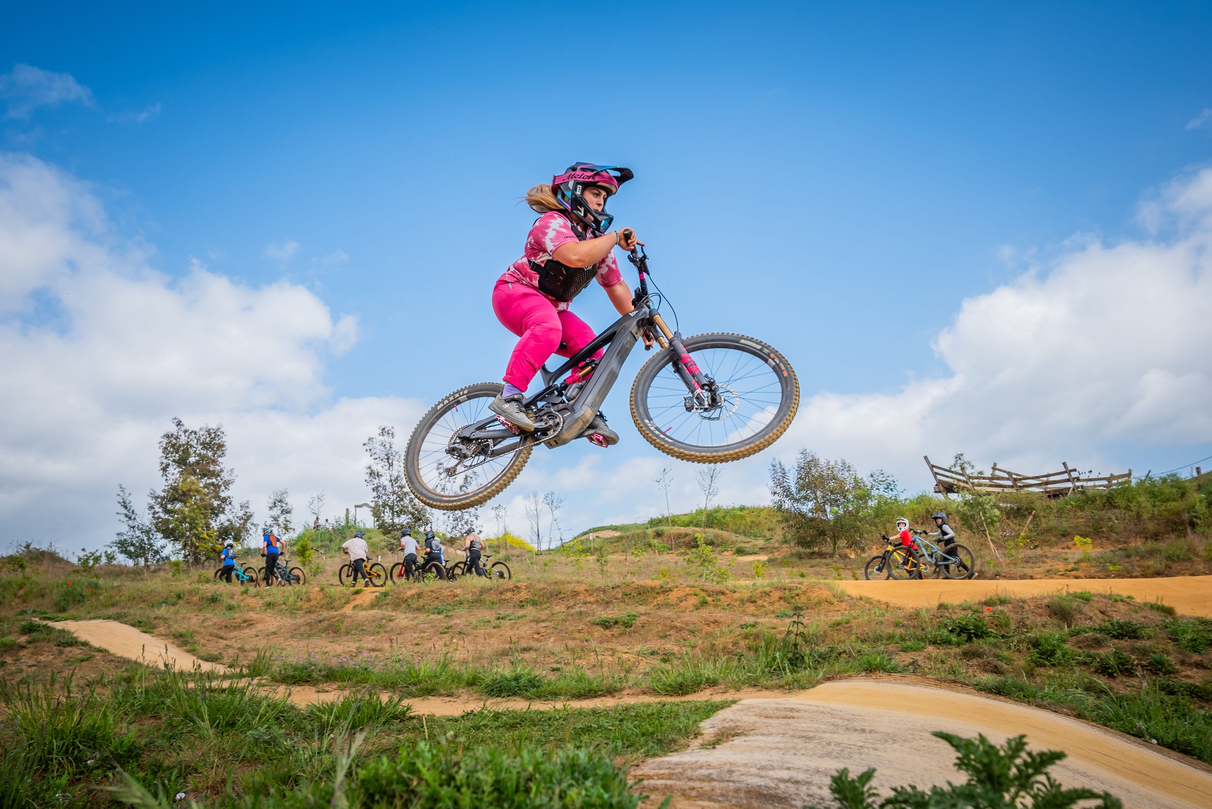 Libby Goffredo jumping a mountain bike against a blue sky