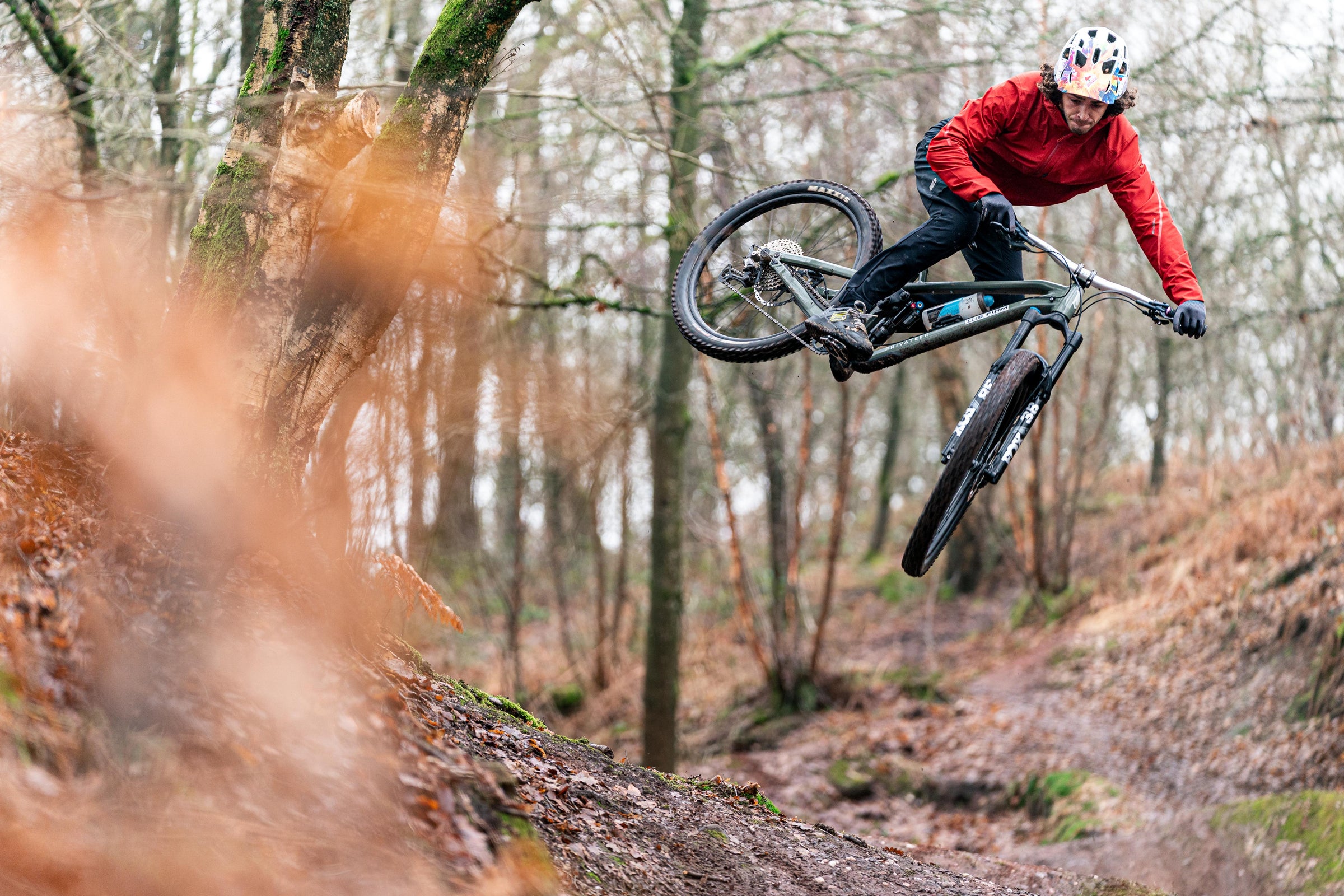 Owen Robinson performing a whip on a mountain bike in woodland