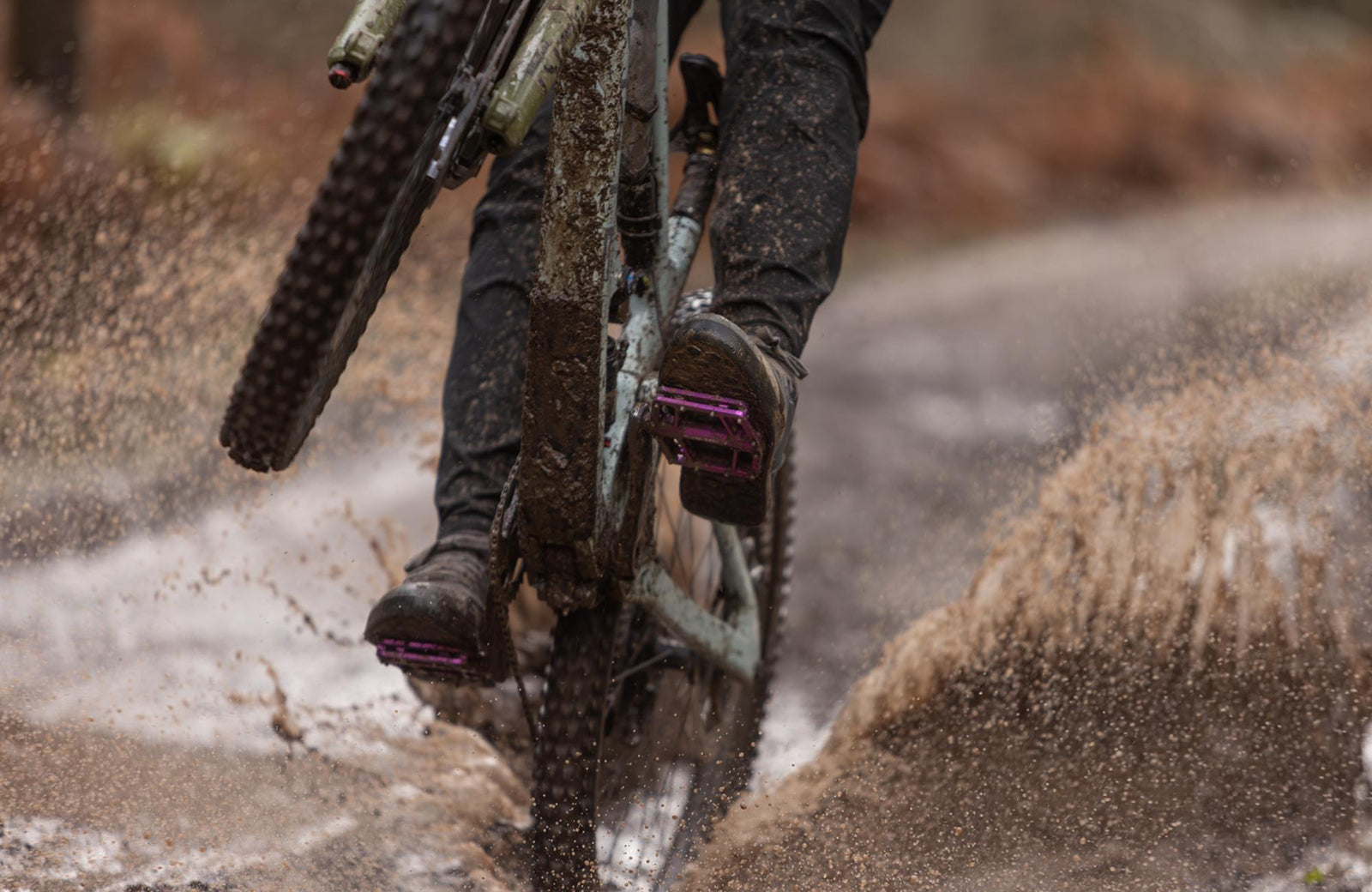 Pilote VTT utilisant des pédales PEMBREE D3A dans l’eau profonde et la boue